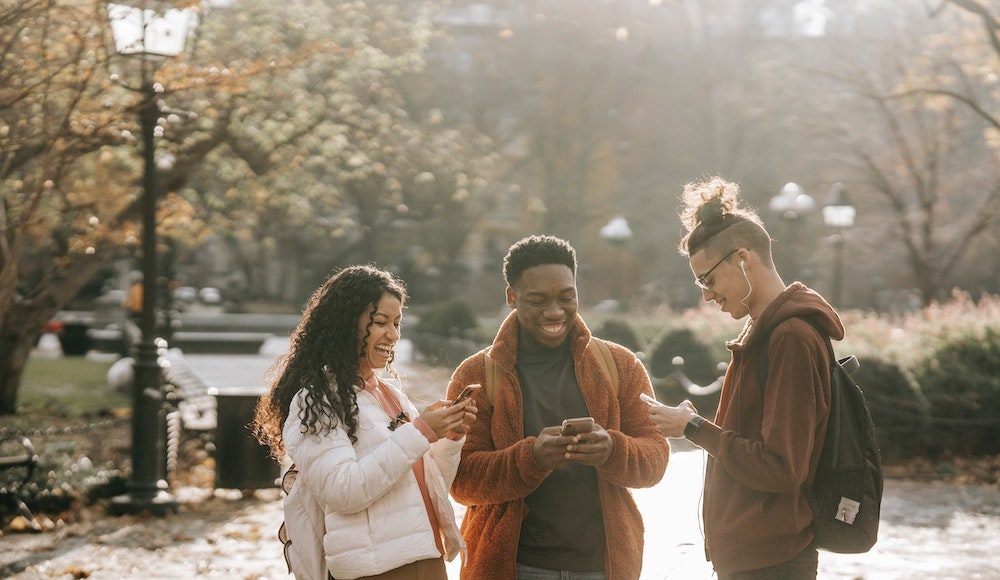 friends looking down at their mobile phones